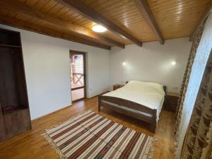 a bedroom with a bed and a wooden ceiling at На Замковiй горi in Kosiv