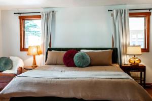 a bedroom with a large bed with two windows at Creek-Hot Tub-View-Pets-10min DT in Durango