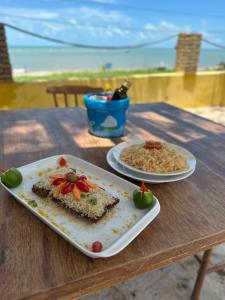 a table with two plates of food on a table at Pousada Amor a Mar Pé na Areia na Praia de Barreiras, Icapuí in Icapuí