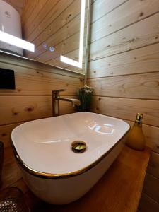 a white tub in a bathroom with a wooden wall at Файна хата 4 in Synevyrsʼka Polyana +36 photos