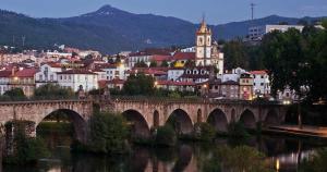 a bridge over a river in a town with a city at Casa acolhedora in Ponte da Barca +8 photos