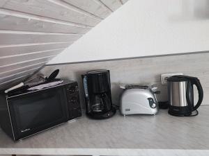 a microwave and appliances sitting on a kitchen counter at Ferienwohnung Wittkatis, ländlich, Nähe Schweriner See in Moltow +8 photos