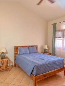 a bedroom with a bed with blue sheets and two lamps at Grand Plaza in San Juan del Sur +60 photos