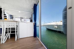 阿尔盖罗Alghero houseboat Blue Zone的阳台配有桌子和水中的船只