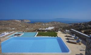 a swimming pool on the side of a villa at Amallini Suites Mykonos in Super Paradise Beach