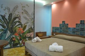 特罗佩阿Kaleido Rooms - Tropea Center的酒店房间里有一张床，上面放着毛巾