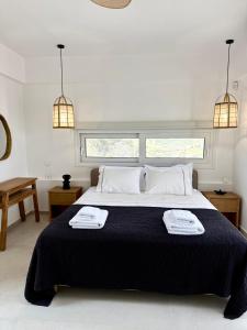 a bedroom with a large bed with two towels on it at PETRA Luxury Villas in Áyioi Apóstoloi