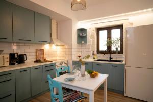 a kitchen with a white table and blue cabinets at Kalithea Chorio 1 in Palekastron