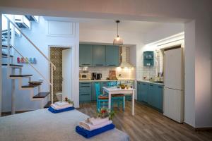 a kitchen with blue cabinets and a table and a staircase at Kalithea Chorio 1 in Palekastron +17 photos