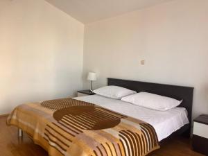 a bedroom with a bed with a blanket on it at Apartment Milat in Seget Donji