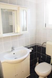 a bathroom with a white sink and a toilet at Apartment Milat in Seget Donji +7 photos