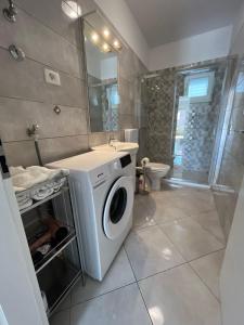a bathroom with a washing machine and a sink at Apartments Cezar in Stobreč