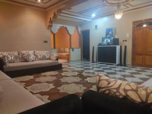 a living room with a couch and a tv at Mogadorista pour les familles in Essaouira