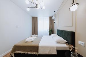 キシナウにある2BR in Central Chișinău Walk to Piața Centralăのベッドとシャンデリアのある寝室