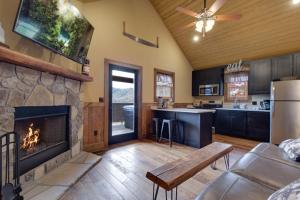 a kitchen and living room with a fireplace in a house at Lost Horizon by Venture Smoky Mountains in Sevierville