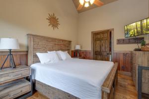 a bedroom with a large white bed and wooden floors at Lost Horizon by Venture Smoky Mountains in Sevierville +25 photos