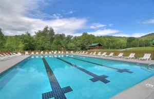 a swimming pool with chairs and a cross on it at Lost Horizon by Venture Smoky Mountains in Sevierville