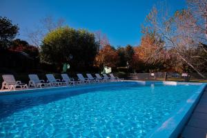 a swimming pool with lounge chairs in a yard at Amanecer en las Piedras in Tandil