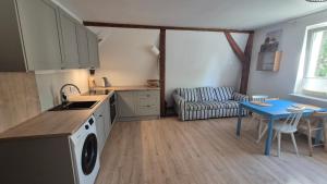 a kitchen with a stove and a table and a couch at Apartament LUA in Ustka