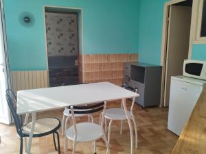 una cucina con tavolo bianco e 4 sedie di Maison de ville - proche Le PAL - DOMPIERRE a Diou 1 altra foto