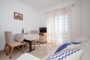 Una sala de estar con una mesa y un comedor. en Apartments Vesna, en Rab