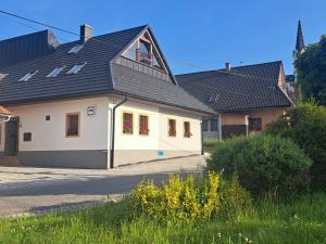 ein weißes Haus mit einem schwarzen Dach in der Unterkunft Privat LeNa in Ružomberok