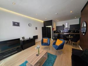 a living room with two blue chairs and a table at Deluxe 2BR Apartment Near City Center - Sleeps 6 in Liverpool
