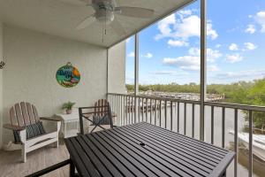 un balcon avec une table, des chaises et un ventilateur de plafond dans l'établissement Bayside Villa 5110- Captiva One Bedroom Deluxe Residence, à Captiva
