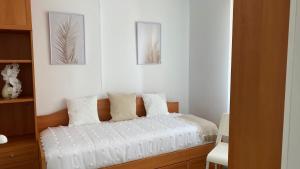 a bedroom with a bed with white sheets and two pictures at La casita de Roque in Villarcayo +4 photos