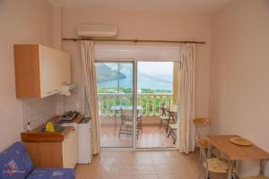 a kitchen and dining room with a view of a patio at Finikas Apartments in Plakias