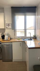 a kitchen with a counter with a sink and a window at La casita de Roque in Villarcayo
