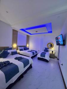 a hotel room with three beds and a flat screen tv at L'ver Hotel in Somoto +25 photos