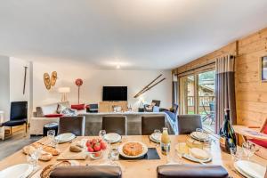 ティーニュにあるRésidence Lodge Des Neiges C - Appartement 4 - pied de pistes, service hotelier inclus MAE-6751のテーブルのあるダイニングルームとリビングルーム