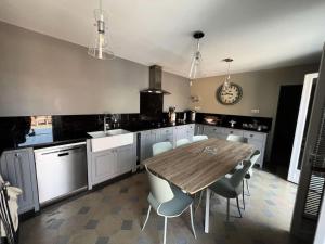 eine Küche mit einem Holztisch und weißen Schränken in der Unterkunft Résidence 191-soulac Sur Mer - 191 - Villa Soulacaise de charme au cœur de Soulac-sur-Mer MAE-9123 in Soulac-sur-Mer