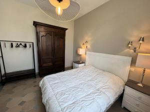 Schlafzimmer mit einem großen weißen Bett und einer Decke in der Unterkunft Résidence 191-soulac Sur Mer - 191 - Villa Soulacaise de charme au cœur de Soulac-sur-Mer MAE-9123 in Soulac-sur-Mer