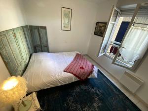 una piccola camera da letto con un letto e una finestra di Résidence Les Vagues - 156 - Appartement en rez de jardin résidence Les Vagues MAE-7381 a Soulac-sur-Mer 1 altra foto