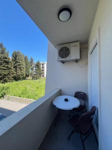 a balcony with a table and a air conditioner at Apartments Nesi in Ulcinj
