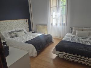 una camera da letto con due letti e una finestra di Maison de ville - proche Le PAL - DOMPIERRE a Diou
