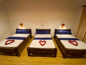 two beds with hearts painted on them in a room at Oasis Bay - Arugam Bay in Arugam Bay