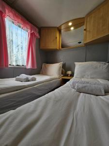 two beds sitting next to a window in a room at Skye Holiday Caravan 6 in Uig