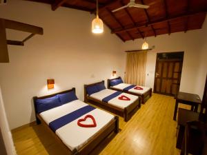 a room with two beds with red hearts on them at Oasis Bay - Arugam Bay in Arugam Bay