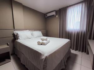 ジョアンペソアにあるApartamentos Família no Aquamarineのタオルが敷かれたベッドのあるホテルの部屋