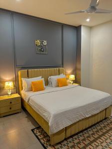 a bedroom with a large bed with orange pillows at 2 BHK Apartment in ISLAMABAD in Islamabad