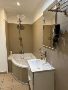 a bathroom with a tub and a sink and a bath tub at appartement centre historique in Bastia +10 photos