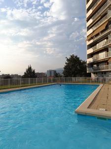 una grande piscina accanto a un alto edificio di Meublé 3 étoiles - PISCINE- BALCON - TENNIS ad Aix-les-Bains