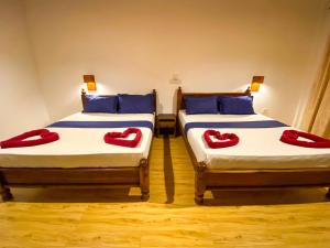 two beds in a room with red pillows on them at Oasis Bay - Arugam Bay in Arugam Bay