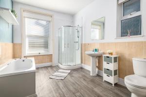 a bathroom with a shower toilet and a sink at Spacious 6 Bed Home in Central Bedford w Parking in Bedford