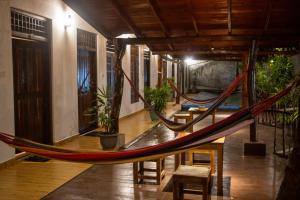 a hammock in a room with tables and chairs at Oasis Bay - Arugam Bay in Arugam Bay