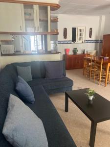 a living room with a blue couch and a table at La mar de bien in El Perelló +10 photos