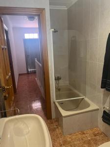 a bathroom with a bath tub and a sink at La mar de bien in El Perelló